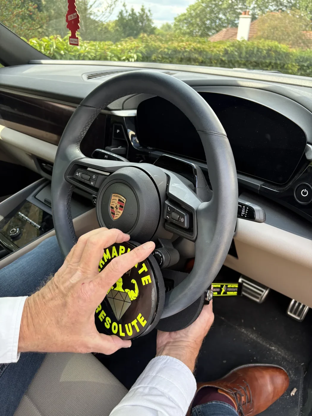 Resolute Diamond held up to a Porsche steering wheel